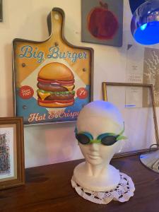 een mannequin met zonnebril en een hamburger op een tafel bij Appartement, cité médiévale in Laon