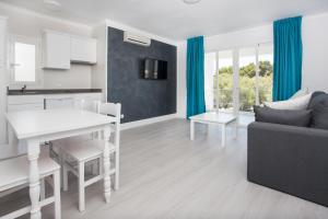 eine Küche und ein Wohnzimmer mit einem Tisch und einem Sofa in der Unterkunft FERRERA SUITES in Cala Ferrera