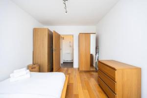 a bedroom with a bed and a wooden dresser at Comfortable 2 Bedroom in Marylebone in London