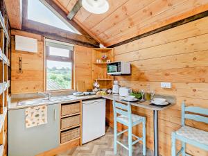 a kitchen with wooden walls and a counter with a table at 1 Bed in Bridport 93355 in Marshwood