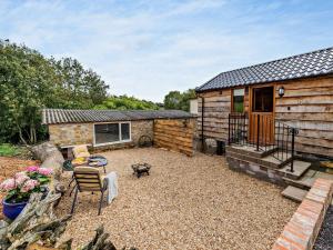 a small cabin with a patio and a table and chairs at 1 Bed in Bridport 93355 in Marshwood