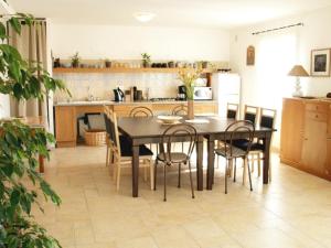 een keuken en eetkamer met een tafel en stoelen bij Chambre avec salle de bain privative comme à l'hôtel et "salon-cuisine" à partager avec les 4 autres locataires in Saint-Maurice-de-Gourdans