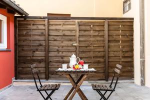a table with a tea set on it in front of a fence at Cortile in centro - Charm Suite Heart of Lucca in Lucca