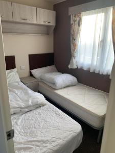 two beds in a small room with a window at Garden View Retreat in Ulrome