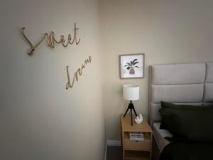 a bedroom with a bed and a sign that reads sweet land at Overleigh Cottage, with optional Hot Tub hire in Chester