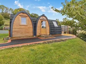 a tiny house with a wooden door in a yard at 1 Bed in Sheinton 93394 in Leighton