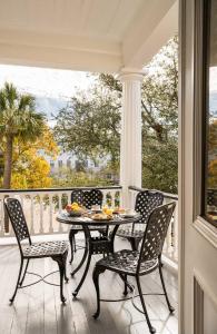 a porch with a table and chairs on a balcony at The Jasmine House in Charleston