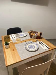 un tavolo di legno con piatti e bicchieri di L'obiettivo ad Assemini