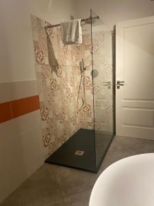 una doccia con porta in vetro in bagno di L'obiettivo ad Assemini