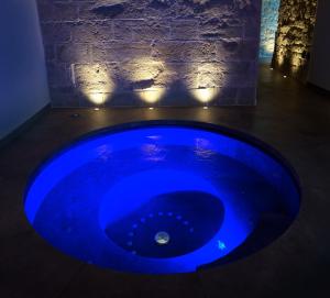 - une baignoire bleue dans une chambre sombre éclairée dans l'établissement Monastero Sant'Alberico Relais, à Balze