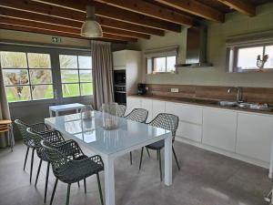 a kitchen with a white table and chairs at Te Lande, vakantiehuis in Veurne