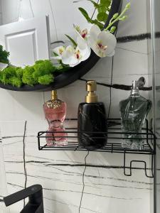 a shelf with perfumes and flowers on a wall at Evelyn Apartment in Bistriţa