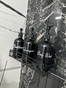two black bottles sitting on a counter in a bathroom at Evelyn Apartment in Bistriţa