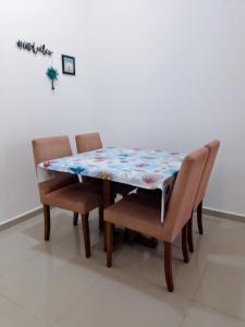 uma mesa de jantar e cadeiras com uma colcha em Residencial North Paradise 106 em Florianópolis