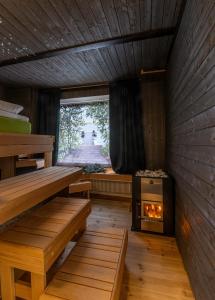 a sauna with a stove in the middle of a room at Mäkkylän Helmi in Helsinki