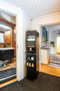 a kitchen with a refrigerator in a room at The Mäkkylä Escape - Perfect for 2 with sauna look and optional Hot Tub in Helsinki +18 photos