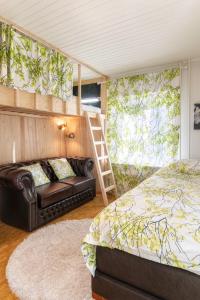 1 dormitorio con cama, sofá y escalera en Mäkkylän Helmi en Helsinki