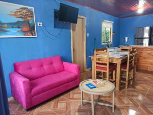 een woonkamer met een roze bank en een tafel bij Cabañas los tres hermanos in Linares