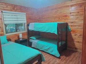 Łóżko lub łóżka piętrowe w pokoju w obiekcie Cabañas los tres hermanos