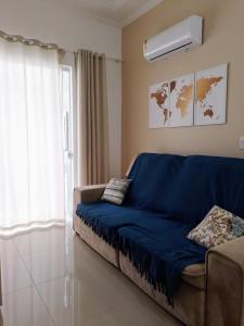 sala de estar con sofá azul y ventana en Residencial North Paradise 106, en Florianópolis