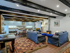 a living room with two blue couches and a kitchen at 3 Bed in Capel-y-Ffin 93362 