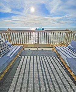 una terraza con 2 bancos en un balcón con vistas al océano en D22 - SeaLuxe, en Oceanside