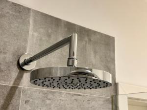 a bathroom sink with a shower head on a wall at Downtown Apartments Leipzig in Leipzig