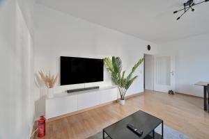 un soggiorno bianco con TV a schermo piatto su una parete bianca di Goodliving Apartments mit Netflix Büro und Parkplatz a Essen