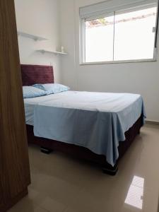 um quarto com uma cama grande e uma janela em Residencial North Paradise 106 em Florianópolis