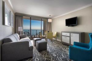 een woonkamer met een bank en stoelen en een televisie bij Breakers Resort Hotel in Myrtle Beach