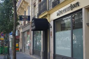 a street with a store on the side of a building at Hotel Beausejour in Paris