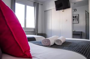 a hotel room with two towels on a bed at Hôtel Le Tivoli in Sisteron
