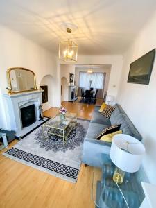 a living room with a couch and a fireplace at Stunning Modern Cozy 5 star 3 bedroom house-Free Parking Greater London Metro Stations hosted by Tony in Catford