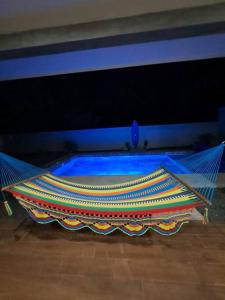 a hammock in a room with a blue pool at Casa Kamima near playa Conchal! in Brasilito