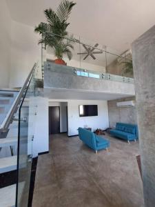 una sala de estar con 2 sillas azules y una escalera en Casa Kamima near playa Conchal! en Brasilito