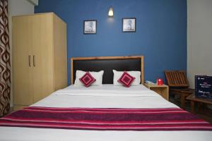 a bedroom with a large bed with two red pillows at Flagship 9046 Hotel Metro Star in New Delhi