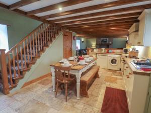 uma cozinha com uma mesa e uma escada em The Barn em Saltburn-by-the-Sea