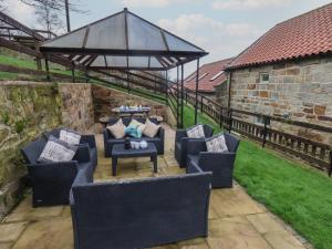 an outdoor patio with couches and tables and a large gazebo at The Barn in Saltburn-by-the-Sea