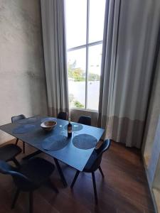 mesa de comedor con sillas, mesa azul y ventana en Casa Kamima near playa Conchal! en Brasilito