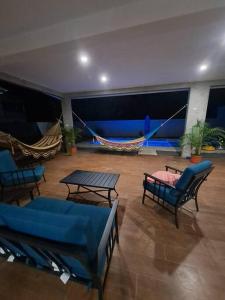 una habitación con sofás, mesas y hamacas en Casa Kamima near playa Conchal! en Brasilito