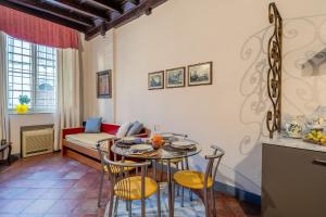 ein Wohnzimmer mit einem Tisch, Stühlen und einem Sofa in der Unterkunft San Pietro Somaldi Apartment in Lucca