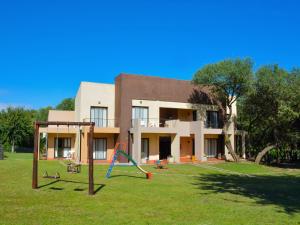 una casa con un parque infantil delante de ella en Apart Entrepiedras en Merlo