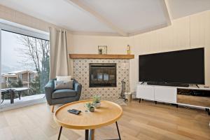 a living room with a television and a fireplace at Hotel du lac by Rendez-Vous Mont-Tremblant in Mont-Tremblant