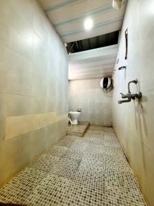 a bathroom with a toilet and a tiled floor at Hermit crab 19 in Ullāl