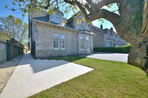 una casa con un árbol delante de ella en 5 star luxury villa with Garden SPA, en St Andrews