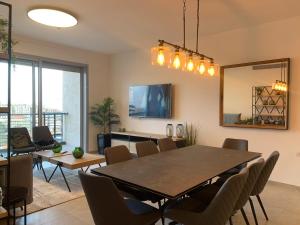 comedor con mesa y sillas en Brand New 3 Bedroom Apartment in Shalem Tower, en Jerusalén