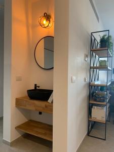 baño con lavabo y espejo en la pared en Brand New 3 Bedroom Apartment in Shalem Tower, en Jerusalén