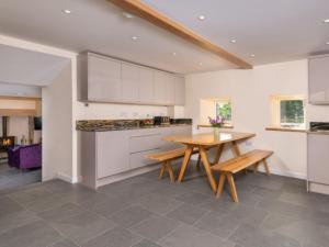 a kitchen with white cabinets and a wooden table at 3 Bed in Askham 93429 in Askham