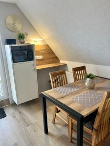uma sala de jantar com uma mesa e um frigorífico em Ferienwohnung Joanna em Norddeich