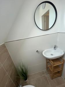 een badkamer met een wastafel en een spiegel bij Ferienwohnung Joanna in Norddeich